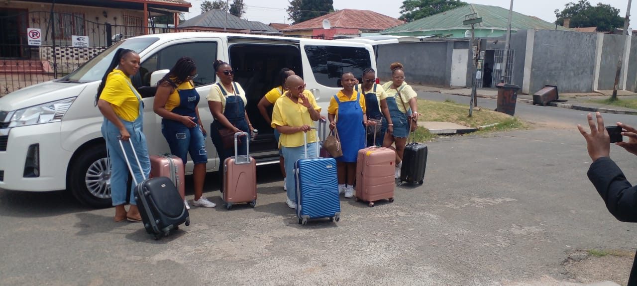Group of travellers loading luggage into an Ahifambi shuttle van